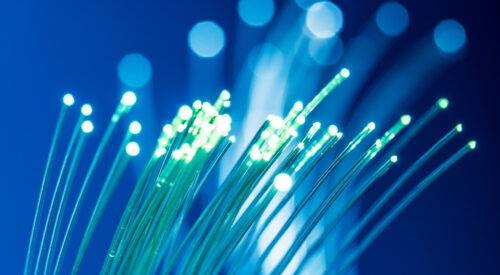 Bundle of optical fibers with lights in the ends. Blue background.